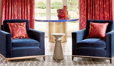 Dark blue velvet matching chair with red cushions in lounge Dark blue velvet matching chair with red cushions in lounge